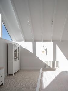Light floods into the master bedroom with exposed beams on the vaulted ceiling of this new build south of Cambridge.